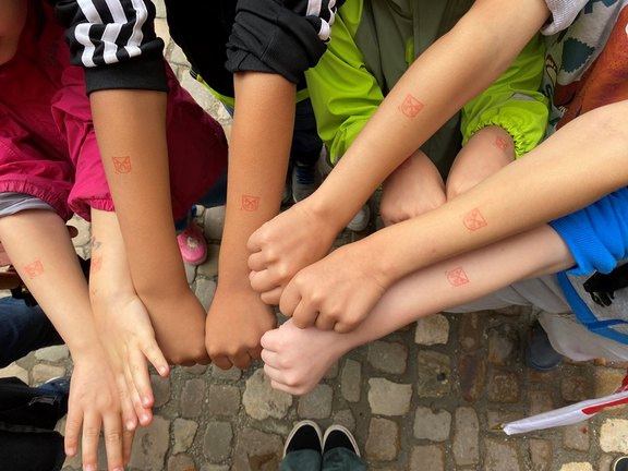 Das Bild zeigt mehrere Kinderarme mit Stempeln.