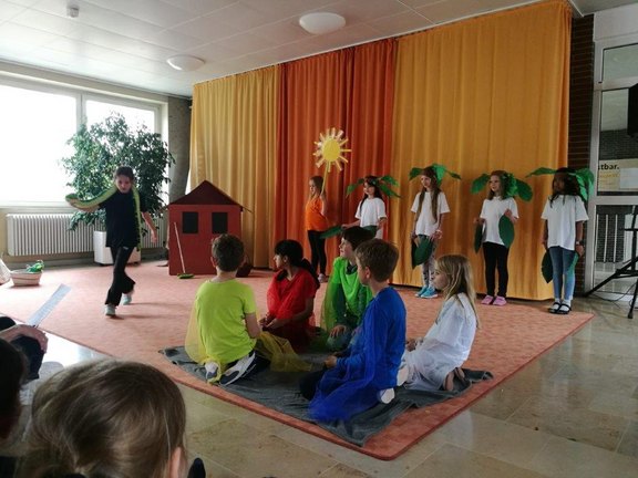 Das Bild zeigt mehrere Kinder, die ein Theaterstück aufführen.