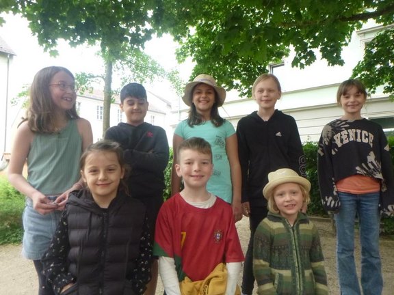Das Bild zeigt insgesamt acht Kinder, die in zwei Reihen nebeneinander stehen und in die Kamera lächeln.