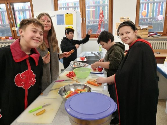 Man sieht Kinder beim Kochen.