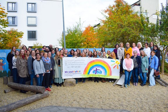 Das Bild zeigt eine Ansammlung von Menschen mit einem Banner.  