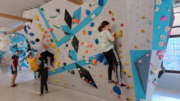 Man sieht Kinder an einer Boulder-Wand