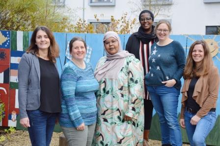 Das Bild zeigt sechs Frauen, die sich nebeneinander für ein Gruppenfoto positionieren.  