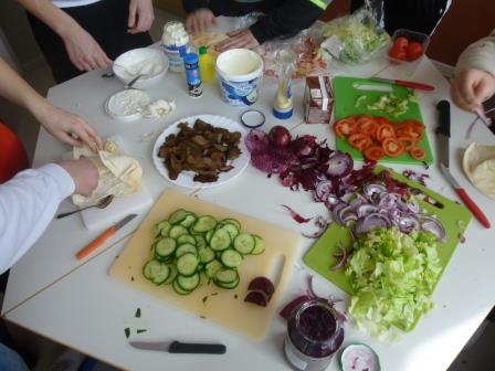 Das Bild zeigt geschnittenes Gemüse und andere Lebensmittel auf einem Tisch. 